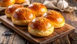 © Yudisa - Golden brown toasted burger buns with sesame seeds sprinkled on top, arranged on a rustic wooden board, ready for a delicious meal