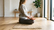 © PTC - Woman meditating cross-legged on a rug in a studio