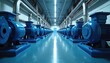 © Pete - Rows of blue electric motors and pumps in industrial facility. Shiny pipes run along ceiling of clean factory hall. Machinery for water treatment or energy production.