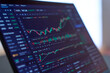 © maru54 - Stock market chart displayed on laptop screen on dark desk