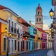 © Nacil - Colorful Colonial Street Lined with Historic Buildings and Church Tower at Dusk