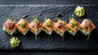 © Uliana - Gourmet salmon sushi rolls with microgreens on dark slate board