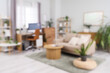 © Pixel-Shot - Blurred view of living room with workplace, sofa and green plants