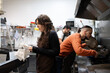 © Ladanifer - Kitchen team actively working together preparing food in a professional restaurant setting