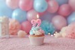 © Namdang - Celebration cupcake with lit number candles and colorful balloons in background