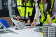 © NINENII - Engineer teams meeting working together wear worker helmets hardhat on construction site in modern city