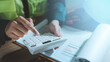 © HappyEva - Cost estimation construction budget planning concept engineer hands using calculator analyzing financial report chart graph expense pricing audit working with hard hat tape measure on desk
