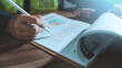 © HappyEva - Green construction environmental sustainability ESG concept engineer hand with pen pointing at net zero report chart cost estimation eco friendly building project management tape measure