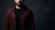 © Luthfi - Close-up portrait of a serious bearded man in a stylish maroon hoodie, showcasing urban casual fashion