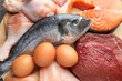 © New Africa - Different types of fresh raw meat, fish and eggs on table, top view