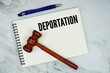 © may1985 - Deportation text written on notepad with pen and judge gavel on marble background