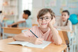 © chokniti - Back to school and education concept of schoolchild classroom child student glasses writing notebook desk education smiling elementary school learning boy portrait young indoors classroom pencil
