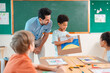 © chokniti - Back to school and education concept of classroom teacher helping child with drawing, creative art lesson in school