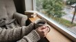 © ROWSHAN - Person holding coffee cup by rainy window with books on sill