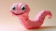 © Mariya - cheerful pink origami worm with big round eyes and a wide smile, segmented paper body with curled tail on a soft pastel background