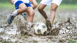 © Bonsales - Children playing soccer on muddy field, legs kicking ball, dynamic action splashing mud, youth enjoying sport