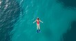 © Yaa - Woman snorkeling in clear blue ocean.