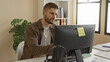© Krakenimages.com - Man at desktop computer rubbing his forehead and massaging his temple while seated at desk in building; work stress frustration.