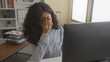 © Krakenimages.com - Woman pinching bridge of nose at computer in office building, hand to face and glasses resting on nose; work fatigue.