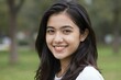 © Studicon - Attractive young woman with dark hair smiles outdoors in soft focus backdrop