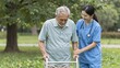 © Studicon - Nurse assisting senior man with walker during walk in the park on a sunny day