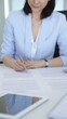 © volha_r - Professional woman signing contract documents, formal agreement paperwork, completing legal work, preparing for business negotiation in office environment