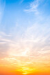© ISENGARD - Sky sunset,Beautiful sunrise sky with vibrant gradient orange and gold colors and soft blue, Clear atmosphere with wispy clouds. Peaceful, perfect for background and copy space, vertical