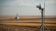 © A2Z AI  - Modern Environmental Monitoring Device on Tripod in Arid Field with Blurred Background and Horizon, Capturing Data Remotely