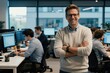 © Pete - Smiling man stands with crossed arms in modern office with team working at computers. Pro leader oversees development team in busy tech workplace. Diverse employees collaborate on software project.