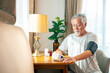 © CandyRetriever  - Asian senior man measuring blood pressure at home using digital monitor, elderly person checking hypertension and cardiovascular health during daily healthcare routine and wellness monitoring
