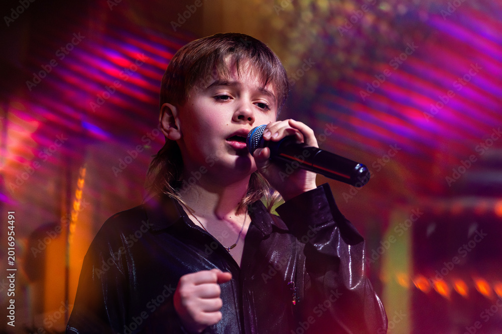 Young boy singer performing on stage with microphone. Stock Photo ...