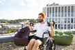 © sofiko14 - A determined man with a beard and bun hairstyle sits in a wheelchair on a rooftop, lifting dumbbells as part of his workout routine