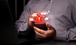 © Wachirapong - A close-up of a person using a mobile phone surrounded by warning symbols, representing mobile banking fraud, SMS phishing (smishing), and online security threats in the 2026 digital era.