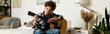 © LIGHTFIELD STUDIOS - Teenager strumming guitar creatively in a cozy home setting surrounded by soft lighting and plants