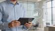 © Charlotte - Business strategy and digital marketing concept with man holding tablet surrounded by holographic icons representing global network, analytics, ideas and communication tools for