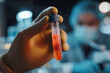 © Michał Magiera - Close Up of Medical Gloved Hand Holding Positive Virus Test Sample in Modern Laboratory Environment