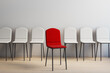 © Who is Danny - Single red chair standing out among uniform white chairs in a modern empty interior room symbolizing choice and uniqueness. 3D Rendering