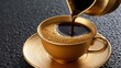 © 69 - Close-up of hot black coffee being poured into a golden ceramic cup with matching saucer on textured black surface for elegant beverage experience