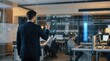 © Jo - Businessman Tracking Agile Development Sprint and Data Milestones on Holographic Smart Glass Wall in Busy Open-Plan Tech Office