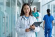 © Asier - Confident asian female healthcare professional looking at camera in a clinic setting