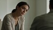 © Future Vision - Leaning woman wearing beige cardigan green top, listening in quiet office with chairs, window light