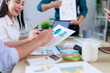 © Crystal - Colleagues collaborating during an office meeting, reviewing charts and graphs on documents and discussing new business plans