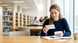 © Xenia - Young woman studying biology with flashcards in a university library. Focused female college student preparing for exams at a desk with notebook and pen. Higher education and learning concept