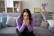 © ADDICTIVE STOCK - Sad woman sitting on sofa at home feeling depressed