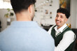 © Studio Marmellata - Two men are engaged in a conversation, one smiling broadly while the other is seen from behind.