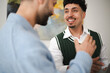 © Studio Marmellata - Two men are engaged in a conversation, one smiling broadly while the other gestures with his hand.