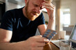 © Davor - Stressed man with headache choosing pills at home office