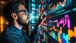 © istia - A businessman in glasses analyzes data on a large screen, using his finger to interact with the information.