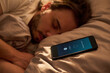 © pressmaster - Close up of Caucasian young adult man sleeping beside smartphone alarm on bed, showing morning wake up routine and digital dependence. Ideal for sleep habits, wellness, burnout themes
