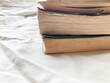 © みずもり - 読書・アンティーク・積み上げられた古い本と布の背景・経年変化で日焼けした古本のページ・クローズアップ